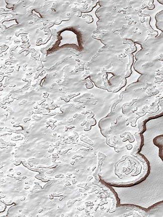 Mars Orbital Camera (MOC) view of the Martian south polar residual mesas and pits in frozen carbon dioxide (MOC2-298), December 6, 2001. The portion of the Martian south polar cap that persists through each southern hemisphere summer is known as the residual cap. In summer, as carbon dioxide is subliming away, the scarps bounding the pits and mesas darken with the red Martian soil, suggesting the layered ice and dust melt. Recent Mars Global Surveyor MOC images acquired in 2001 indicate the scarps are retreating an average of 3 meters (3.3 yards) per Martian year and might mean global warming. Photograph courtesy JPL and Malin Space Science Systems.