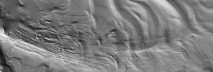 Long, sweeping grooves at least 200 kilometers long and 80 to 100 kilometers wide  in the layered deposits of ice and dust at the south polar cap of Mars.  Photograph courtesy JPL and Malin Space Science Systems.