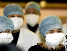Masked medical workers in China.  Photograph © 2003 by AFP.