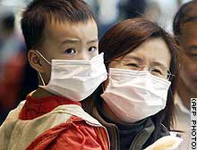 Residents of Hong Kong where the SARS pneumonia virus has been spreading rapidly are wearing surgical masks as a precaution.  Photograph © 2003 by AFP.