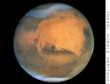 Mars, the fourth planet from the sun, showing its  white icy poles of both carbon dioxide frost and some water ice in contrast with the rusty red, desert surface over the rest of the planet.  Photographed by the Hubble Space Telescope.