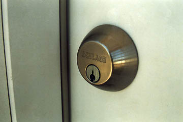 New lock on brand new door surrounded by peeling paint, July 17, 2005. Photograph © 2005 by Linda Moulton Howe.