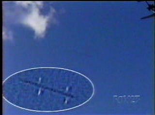 On Sunday, October 20, 2002, at 4:20 p.m. EDT, FOX 23 News videographer, Brandon Mowry, was filming a weather segment for WXXA-TV in Albany, New York. While the camera was still running, he lifted the camera 180 degrees to get another shot of a plane taking off. He did not know at the time that he caught seven frames (1/3rd second) of digital videotape of the jet airliner passing out of the upper right corner and a strange, missile-like, unidentified aerial object rapidly passing through sky and seemingly through a cloud estimated to be at 5,000 feet or more. Darker blue "line" at center of frame is the rapidly moving unidentified object that is enlarged inside the white oval in lower left corner.Videotape © Fox 23 News WXXA, Albany, New York. 