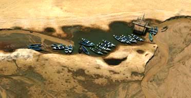 Boats in July 2006 where Amazon waters have dried up in second year of severe drought. Record sea temperatures and illegal logging blamed. Photograph © 2006 by Daniel Beltra/AFP/Getty Images.
