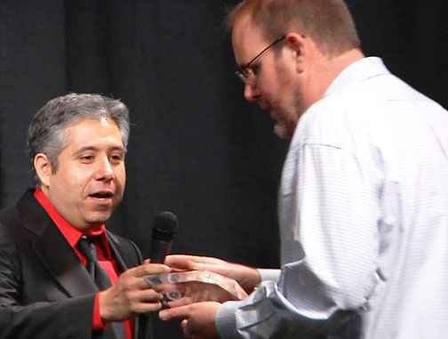 John Burroughs receiving Researcher of the Year Award 2015, from Alejandro Rojas, Director of Operations, 2015 Open Minds International UFO Congress, on Saturday,  February 21, 2015, Fountain Hills, Arizona. Image © 2015 by Open Minds. See Open Minds video about John Burroughs below in More Information.