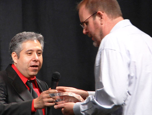 John Burroughs receiving Researcher of the Year Award 2015, from Alejandro Rojas, Director of Operations, 2015 Open Minds International UFO Congress, on Saturday, February 21, 2015, Fountain Hills, Arizona. Image © 2015 by Open Minds. See Open Minds video about John Burroughs below in More Information.