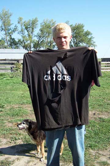 Evan Briese, 16, with a family dog, Rougher Boy, and the Adidas T-shirt that had five slices in it after he became conscious on September 11, 2006. Image © 2006 by Richard Moss and Lorna Hunter.