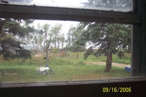  Above:  Evan's point of view looking out kitchen window around 1 a.m. on September 11, 2006. Below:  Just beyond trees are the large corral; long, gray barn; and small pig corral at far end of barn surrounded by sheet metal walls and marked by pink circle. Images © 2006 by Richard Moss and Lorna Hunter.