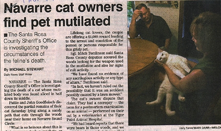 Pattie and John Goodfleisch hold their surviving white female cat, Kitty, after they found their other black male cat, Maximum, cut in half on Saturday, June 30, 2001. Photograph © 2001 by Daily News, Milton, Florida.