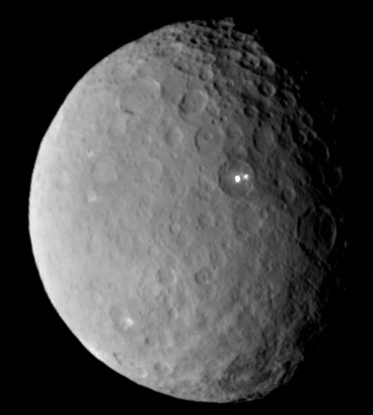 Ceres is near the rocky asteroid belt between Mars and Jupiter, but round and so is called  a dwarf planet. It is small, only 590 miles in diameter, with a surface temperature of minus-105 degrees C. (minus-157 degrees F.). Yet, it's estimated to be 20% water ice and some  scientists think that the bright spots could be fresh ice somehow ejected from below the surface.  Feb. 19, 2015 image by NASA/JPL.