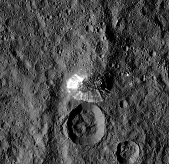 NASA's Dawn spacecraft spotted this tall, conical mountain on Ceres from a distance of 915 miles (1,470 kilometers). The mountain, located in the southern hemisphere, stands 4 miles (6 kilometers) high. Its perimeter is sharply defined, with almost no accumulated debris at the base of the brightly streaked slope. Credits: NASA/JPL-Caltech/UCLA/MPS/DLR/IDA