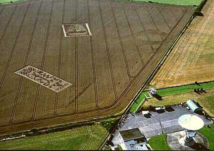 The "binary code" on the left and "face" to the right in the wheat field near Chilbolton Observatory near Wherwell, Hampshire, U. K. were first seen on different dates, according to a Chilbolton Observatory employee. The "face" near top center was reported on Tuesday, August 14, 2001. The "binary code" to the left was reported on Monday, August 20, 2001. Aerial photograph © 2001 by Steve Alexander.