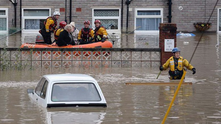 On November 27, 2012, an RNLI life boat rescues residents in the  flooded streets of St Asaph in North Wales after torrential overnight rain on November 27, 2012. Residents in up to 500 homes in St Asaph have been advised to evacuate as flood waters continue to rise and the River Elwy broke its banks.  By November 29, serious and unusual flood warnings have spread  throughout the U. K. Image © 2012 by The Telegraph.