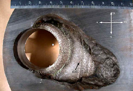 Leaking boric acid ate a 6-inch wide hole around the steel cladding of Nozzle #3 in the reactor head at the Davis Besse nuclear power plant near Toledo, Ohio. Discovered in 6-inch steel casing and photographed in March 2002. Plant shut down to avoid potential core melt down. Photograph from Nuclear Regulatory Commission.