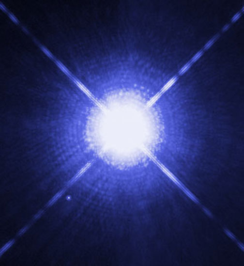 The huge, Sirius A, is twice as massive as our Sun and is the brightest star in our Earth night sky. In the lower left, the tiny white dot is its solar companion, the white dwarf Sirius B. The two stars revolve around each other every 50 years exactly as the Dogon tribe told the French anthropologists between 1915 and 1930 in West Africa. Sirius A is only 8.6 light-years from Earth and is the fifth closest star system known. Image by Hubble and NASA.