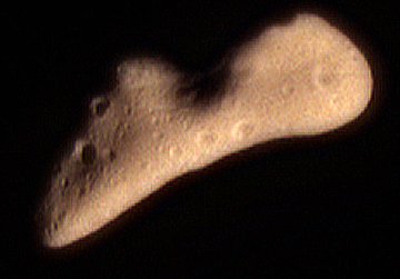 This color image of Eros was acquired by NEAR's multispectral imager on February 12, 2000 at a range of 1800 kilometers (1100 miles). Eros is 34 kilometers (21 miles) long, about 11 kilometers (7 miles) wide and a hundred million miles from Earth in the asteroid belt between Earth and Mars. The butterscotch hue is typical of a wide variety of minerals thought to be major components of asteroids such as Eros which has very little metal. Photograph from NEAR satellite courtesy of JHU Applied Physics Laboratory, Laurel, Maryland.