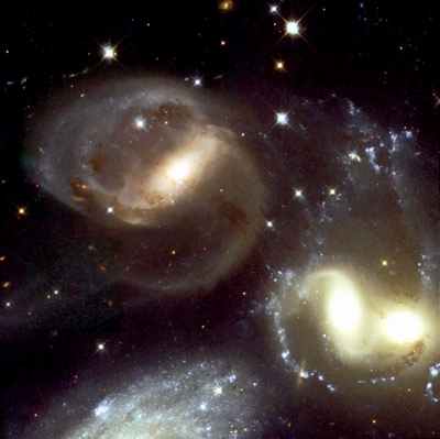 Hubble Space Telescope image of Stephan's Quintet center where three galaxies are colliding 270 million light years from earth. The partial galaxy image at the bottom of the frame is now seen to be a much closer galaxy only 35 million light years away. Photograph courtesy European Space Agency and NASA.