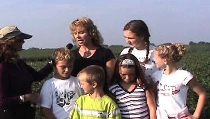 Linda Moulton Howe interviewing Juliet Vanopdorp of Annawan, Illinois, (near Geneseo) with her 13-year-old daughter, Chloe (braids); 9-year-old Beau (front left); his 5-year-old brother, Zack (chartreuse shirt); 8-year-old sister Claudia; Claudia's 8-year-old friend, Brook. Video frame by Ted Robertson for © 2006 Earthfiles.