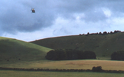 British Army helicopter descending over flower formation (discovered July 14, 2000) in East Field during aerial maneuvers by four helicopters flying between East Field, West Stowell/Oare, Pickled Hill and Woodborough Hill over several hours on August 3, 2000. Photograph © 2000 by Linda Moulton Howe.
