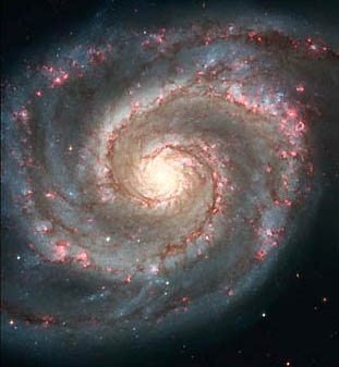 Sharpest image of the Whirlpool Galaxy ever taken was made by NASA's Hubble Space Telescope in January 2005. The pink arms are "star-formation factories, compressing hydrogen gas and creating clusters of new stars." Each arm of stars moves forward through changing densities of gas and dust, as our solar system moves with its Sun in the rotating arms of our Milky Way Galaxy. Image credit: NASA, ESA, and Hubble Heritage Team.