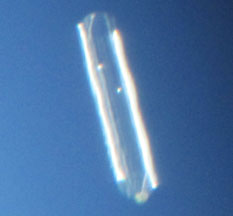 October 16, 2012, 2 to 4:30 PM, mysterious,  unidentified aerial object remained stationary above airliner traffic, perhaps near 50,000 feet or more in the rapid jet stream. How could the object remain stable and unmoving for 2.5 hours? Telescope image © 2012 by Allen Epling. 