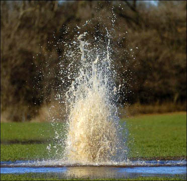 Natural gas spews ground water 7 to 10 feet into the air from a farmer's wheat field southwest of Kingfisher on Monday, December 12, 2005. This is the largest of numerous geysers spotted in Kingfisher and Canadian Counties along Winter Camp Creek, which runs near Kingfisher and Okarche. Photograph © 2005 by Andy Carpenean, Enid News & Eagle.