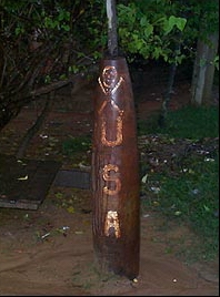 Skull and crossbones "poison" symbol above USA painted on unexploded bomb in Xepon, Laos. Photograph © 2001 by Martin Geissmann.