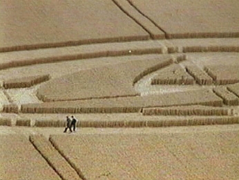 Unidentified, white glowing object moved rapidly across triple crescent formation at Barbury Castle, Wiltshire, England on August 7, 1999. People in formation did not seem aware of the mysterious light seen and videotaped © 1999 by Donald Fletcher of London.