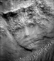 Malin Space Science Systems (MSSS) MOC narrow-angle image M02-03051 of unusual face-like surface feature in valley of Libya Montes near equator on Mars, approximately 275 degrees West and 2.66 degrees North. Image released by MSSS on May 22, 2000. To find this feature, it is necessary to turn the original MOC image upside down.