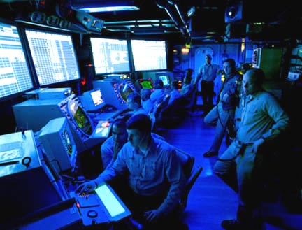 U. S. Navy air traffic controllers man radar screens of Air Operations Center on board the USS Theodore Roosevelt in 1999. Image courtesy U. S. Dept. of Defense.