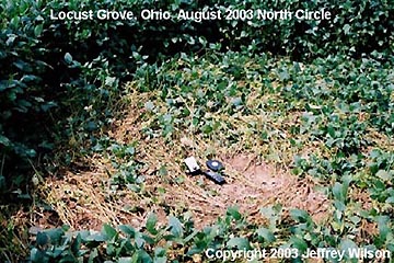 Pictured in the far northern circle is Jeff Wilson's TriField Natural EM Meter, Garmin GPS 2000, and a Stanley 100ft tape measure. The center of this smaller circle was offset from true center. Eccentric deviations of the crop swirled centers were found in the other three small circles as well. Photograph © 2003 by Jeffrey Wilson.