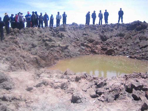 Meteorite crater filled with ground water after 11:34 AM impact on September 15, 2007, in Carancas, Peru, south of Lake Titicaca near Bolivian border. Hole diameter measured between 7.4 to 7.8 meters (26 feet). Ring boundary of ejecta around hole measured between 13.3 to 13.8 meters in diameter. Crater depth to groundwater estimated about 2 meters.