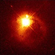 Example of a quasar 1.5 billion light years from earth. This quasar is so bright that it created diffraction spikes on the telescope image. Photograph courtesy Hubble Space Telescope (HStsci).