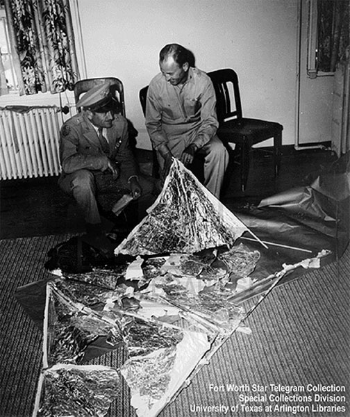 General Roger M. Ramey, with chief of staff Colonel Thomas DuBose in Ramey’s Fort Worth AAF office with pieces of weather balloon on July 8, 1947. This was a cover-up of the UFO that crashed in a sheep pasture between Roswell Army Air Field and Corona on July 3, 1947, discovered by rancher Mac Brazel. RAAF was home of the 509th Bombardment Group, one of the first units assigned to the Strategic Air Command and the only atomic bomber base at the time. Part of the 509th BG was previously designated the 509th Composite Group, which dropped the atomic bombs on Hiroshima and Nagasaki, Japan, in August 1945, the end of World War II.