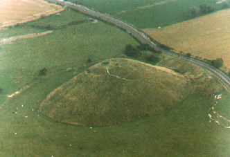 Silbury Hill near Avebury, Wiltshire, England, circa 3700 B. C., the largest artificial mound in Europe, 130 feet high and covers five acres. On May 31, 2000, a resident found a hole on top. By June 11, 2000, the hole is 50 feet deep and about 6 feet wide. Aerial photograph © 1993 by Linda Moulton Howe.
