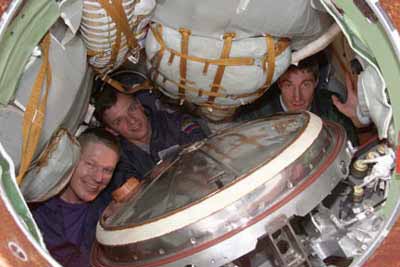 International Space Station's first crew, left to right: William Shepherd, United States; Yuri Gizenko and Sergei Krikalev, Russia. Inside the Soyuz capsule for final time before historic launch at 2:53 AM EST on October 31, 2000 to spend at least four months orbiting the earth. Photograph courtesy NASA 2000.