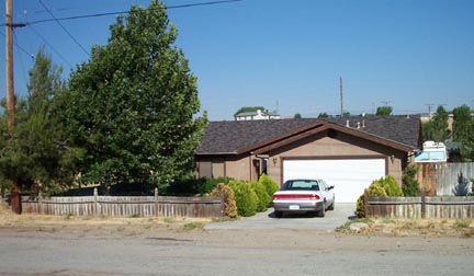 Neil Browning's house in Tehachapi, California west of Edwards Air Force Base  where he works as an F-16 crew chief. His car is parked in front of the garage where the buzzing  light encounter took place around 12:15 a.m. PDT on July 11, 2002. At the right beyond the fence  is the trailer that Neil retreated to in fear after the encounter with the light in the garage.  Photograph taken on July 23, 2002 by Neil Browning.