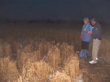 Crop circle investigator and author, Barbara Lamb, with a colleague standing in the ring of wheat bundles furthest from the mound. Image © 2006 by Jennifer Kreitzer. 