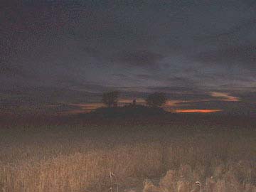 Red western sky beyond the Charlbury mound and the bundles of wheat inside the circle furthest from the mound in the lower right. Image © 2006 by Jennifre Kreitzer. 