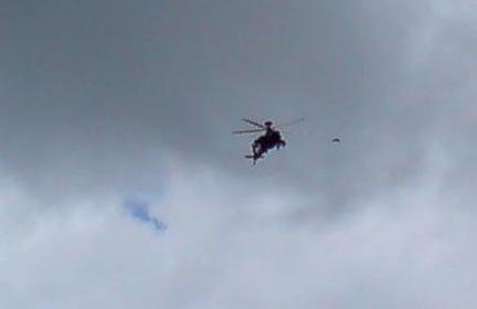 Black, unmarked Apache helicopter hovered above cameraman Winston Keech in the East Field formation on July 10, 2007. Dark object to right of helicopter is unidentified. Video image © 2007 by Winston Keech.