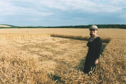 Linda standing in corner of one of the "crystal" ends that were "faceted" by sections of wheat laid down at 90-degree angles and woven with the rest of the downed crop, Wayland's Smithy crop formation in Oxfordshire, England, on July 30, 2006. Photograph by Shawn Randall.