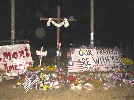 Photograph taken at the public memorial that was created soon after United Flight 93 crashed into the rural field in Shanksville, Pennsylvania. Mysterious translucent spheres cluster around the cross. Photograph © 2001 by Debbie Harris.