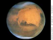 Mars, the fourth planet from the sun, showing its white icy poles of both carbon dioxide frost and some water ice in contrast with the rusty red, desert surface over the rest of the planet. Photographed by the Hubble Space Telescope.
