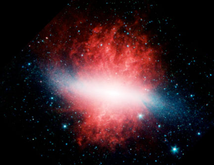 M82 is a “starburst” galaxy 10 million light-years  from our Milky Way galaxy. The mysterious radio wavelengths  appeared very suddenly, have persisted and have never been seen  before in our galaxy. Supernova explosions in the core of the galaxy have produced a hot wind which can be seen escaping in this infra-red image where dust emission is colored red.  Image by NASA/ESA/STScI/AURA.
