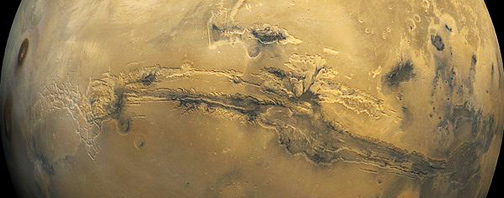 Valles Marineris, our solar system's biggest canyon, runs along the Martian equator for 2,500 miles (4000 km) at depths up to 4 miles (7 km ). For comparison, Arizona's Grand Canyon is about 500 miles long (800 km) and 1 mile deep (1.6 km). Valles Marineris spans one-fifth of the entire distance around Mars! NASA 1980 global mosaic image by Viking 1.