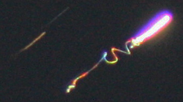 Unidentified, colorful, aerial light photographed (est. 15 second exposure) on November 4, 2009, above Fryeburg, Maine. Upper left streaks are star trails in time exposure. Image © 2009 by Jonathan Spak.