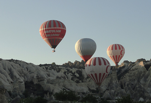 Above and below:  Anatolian and other balloons rising over volcanic landscape of Cappadocia, Turkey, on June 11, 2012. Image © 2012 by Linda Moulton Howe.