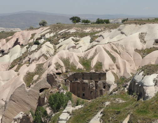 Uchisar gets its name from a Hittite castle built long ago on the ancient Silk Road in the pinkish-beige volcanic rock formations. Today there are large apartment buildings that house many people. The temperature inside remains the same allthrough the year. Expansions occur by simply carving into more surrounding volcanic rock. Image © 2012 by Linda Moulton Howe.