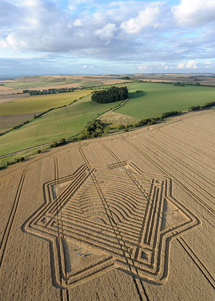 Created on a slanted hillside, the large, 250-foot-diameter  Whitefield Hill “3-dimensional” wheat formation near Woodsend about six miles north of Marlboro, Wiltshire, England, was reported August 3, 2010. Aerial image © 2010 by Olivier Morel. See more images and information:   Cropcircleconnector.com.