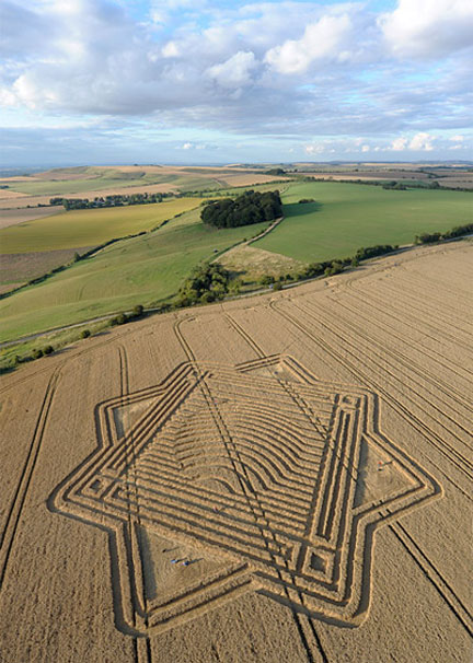 Created on a slanted hillside, the large, 250-foot-diameter Whitefield Hill “3-dimensional” wheat formation near Woodsend about six miles north of Marlboro, Wiltshire, England, was reported August 3, 2010. Aerial image © 2010 by Olivier Morel. See more images and information: Cropcircleconnector.com.
